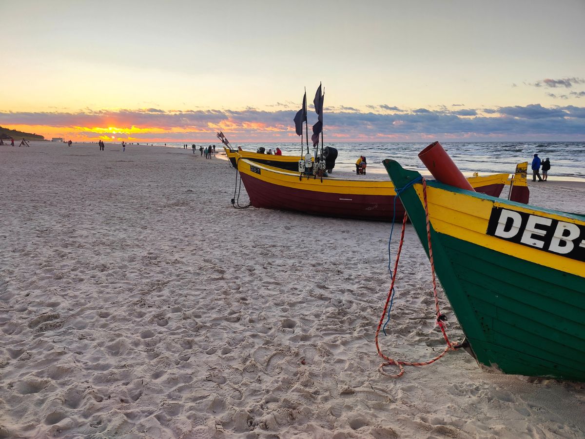 Zachód słońca nad plażą w Dębkach, ciepłe kolory i spokojne fale